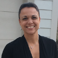 Professional headshot of woman with short hair and warm smile wearing black top
