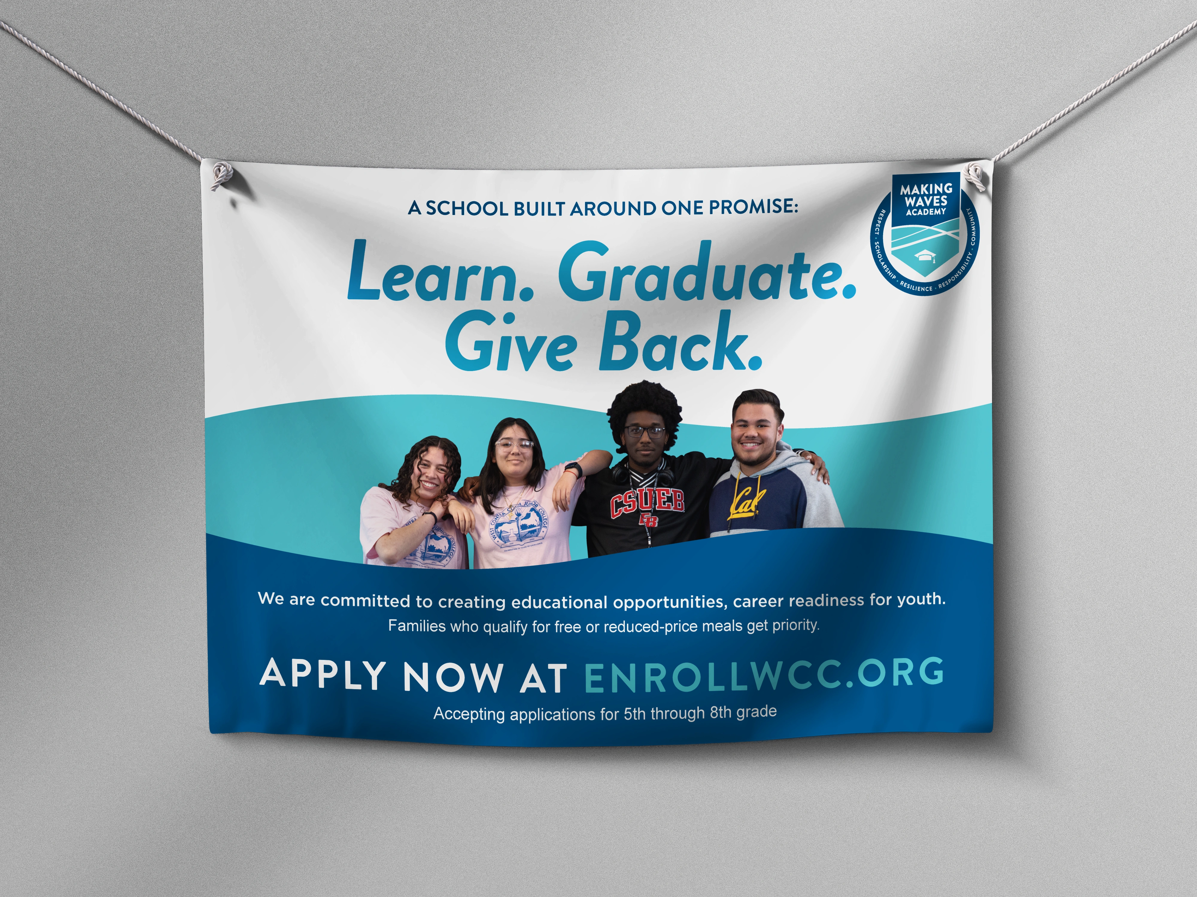 Large outdoor Making Waves Academy banner reading Learn. Graduate. Give Back. with students in college sweatshirts