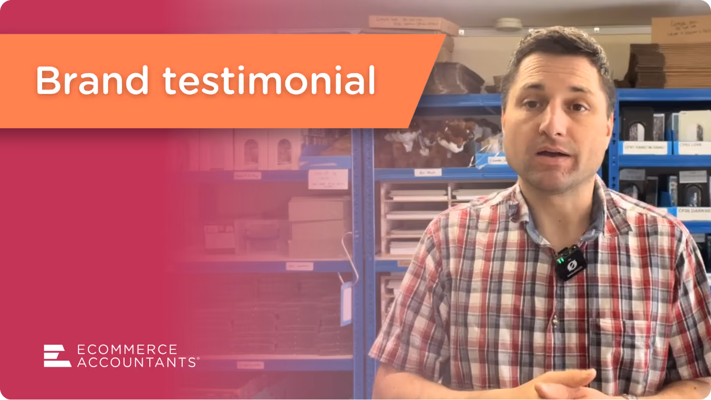 Man in checkered shirt giving a brand testimonial with store shelves in the background.