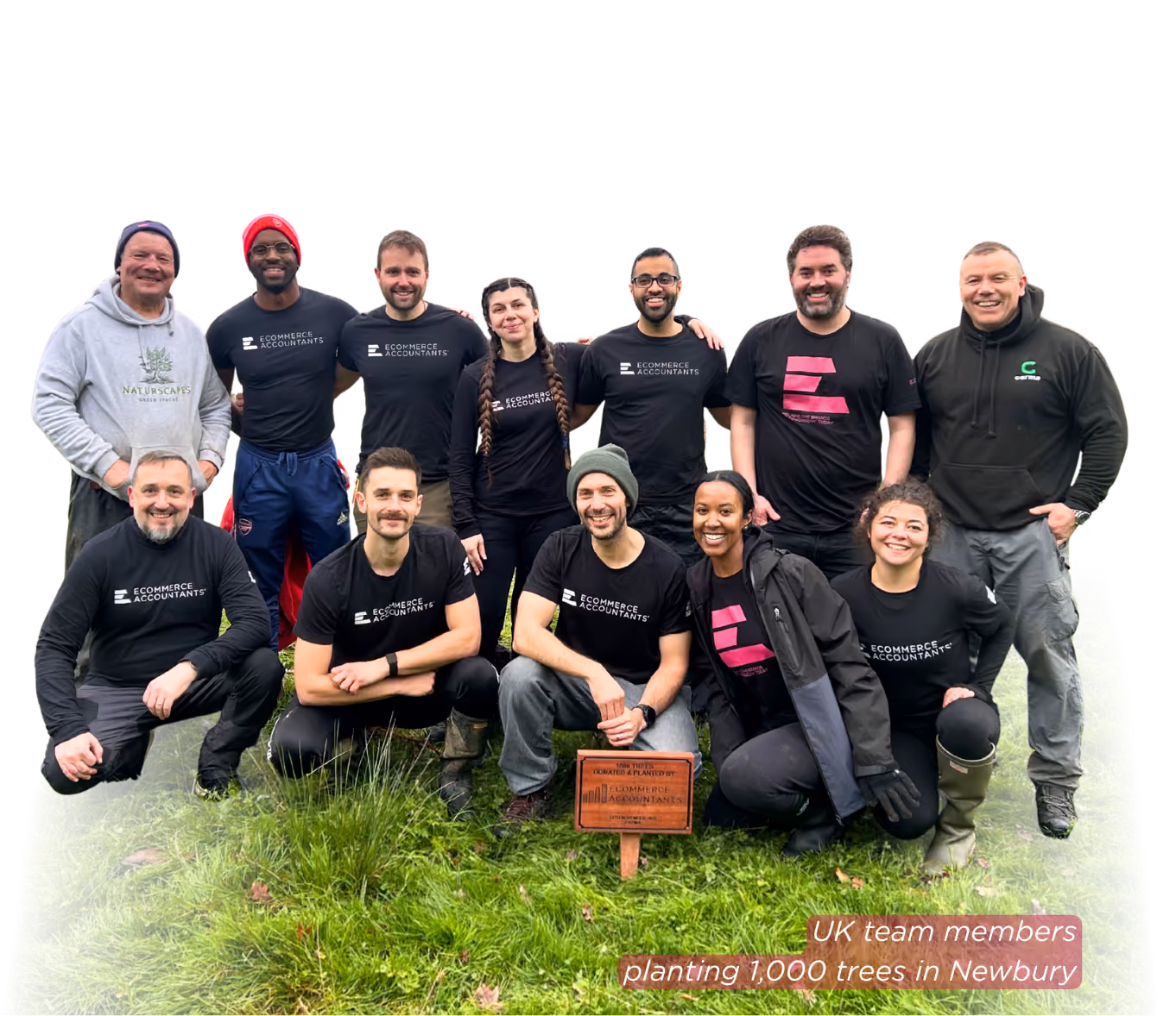 Group of 12 people posing on grass with a plaque about planting 1,000 trees in Newbury.