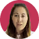 Portrait of a woman with long brown hair against a pink background.