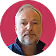 Portrait of a middle-aged man with short gray hair and beard against a red background.