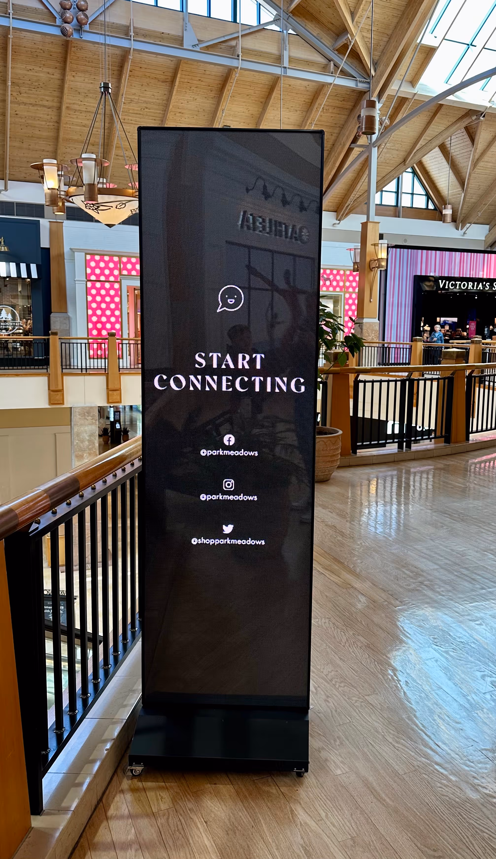 Adxact digital signage promoting DOOH advertising in a mall setting with a start connecting message.