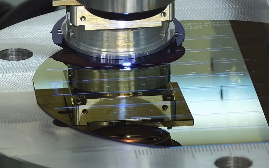 Close-up of a semiconductor wafer under a microscope during an electronic inspection process.