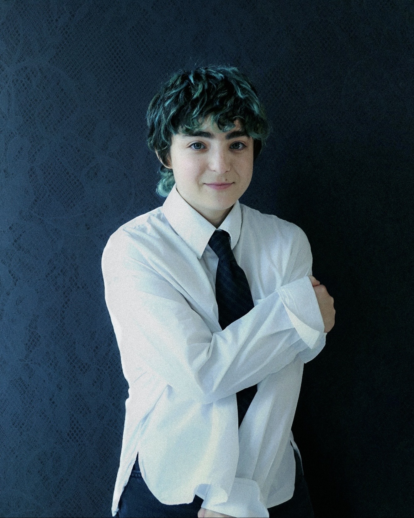 Claud in a white button-down and navy tie with arms crossed in front of a dark lace backdrop, Me and the Music album photoshoot, Medicine Box Magazine 2026