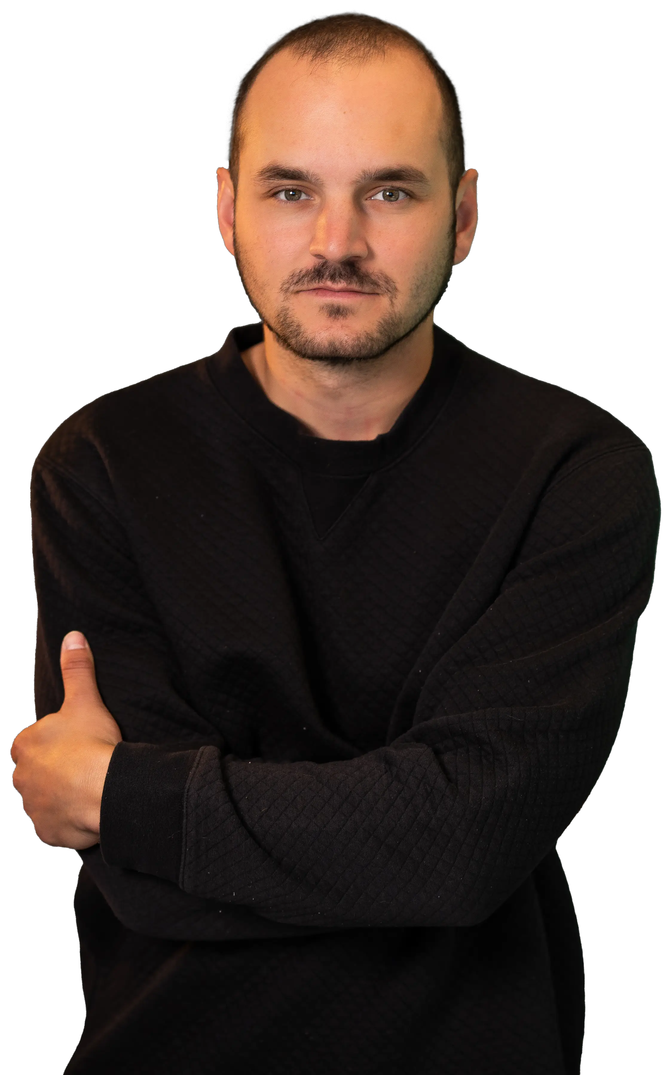 Jacob with his arms crossed looking at the camera in a black sweater