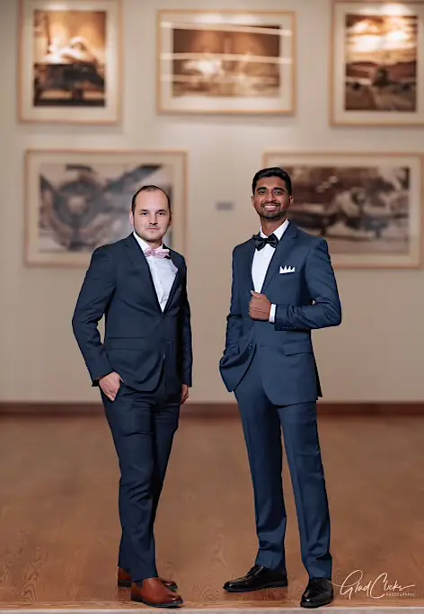 Jacob and a friend wearing suits standing in a large room
