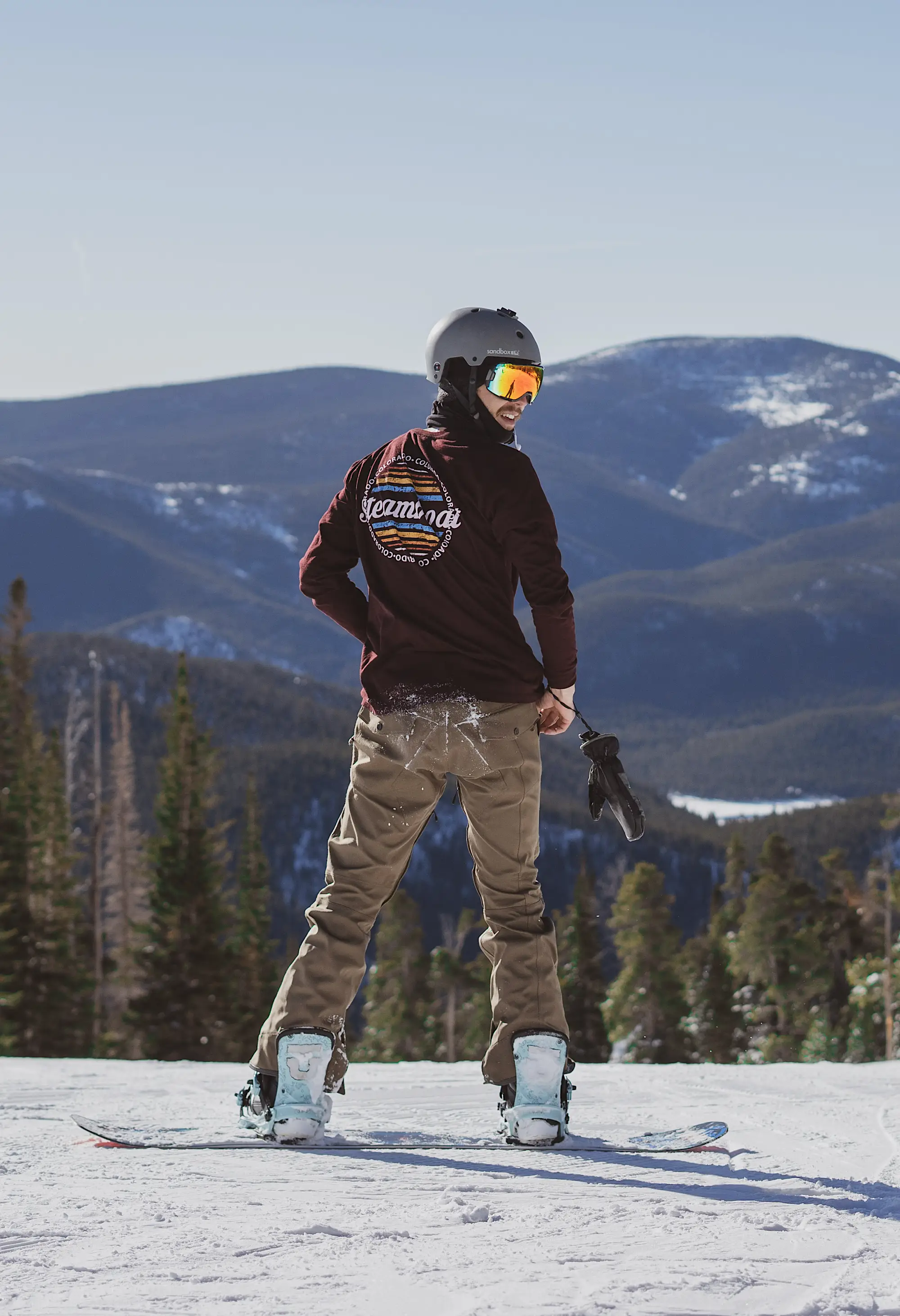 Snowboarding standing still on top of ski slope