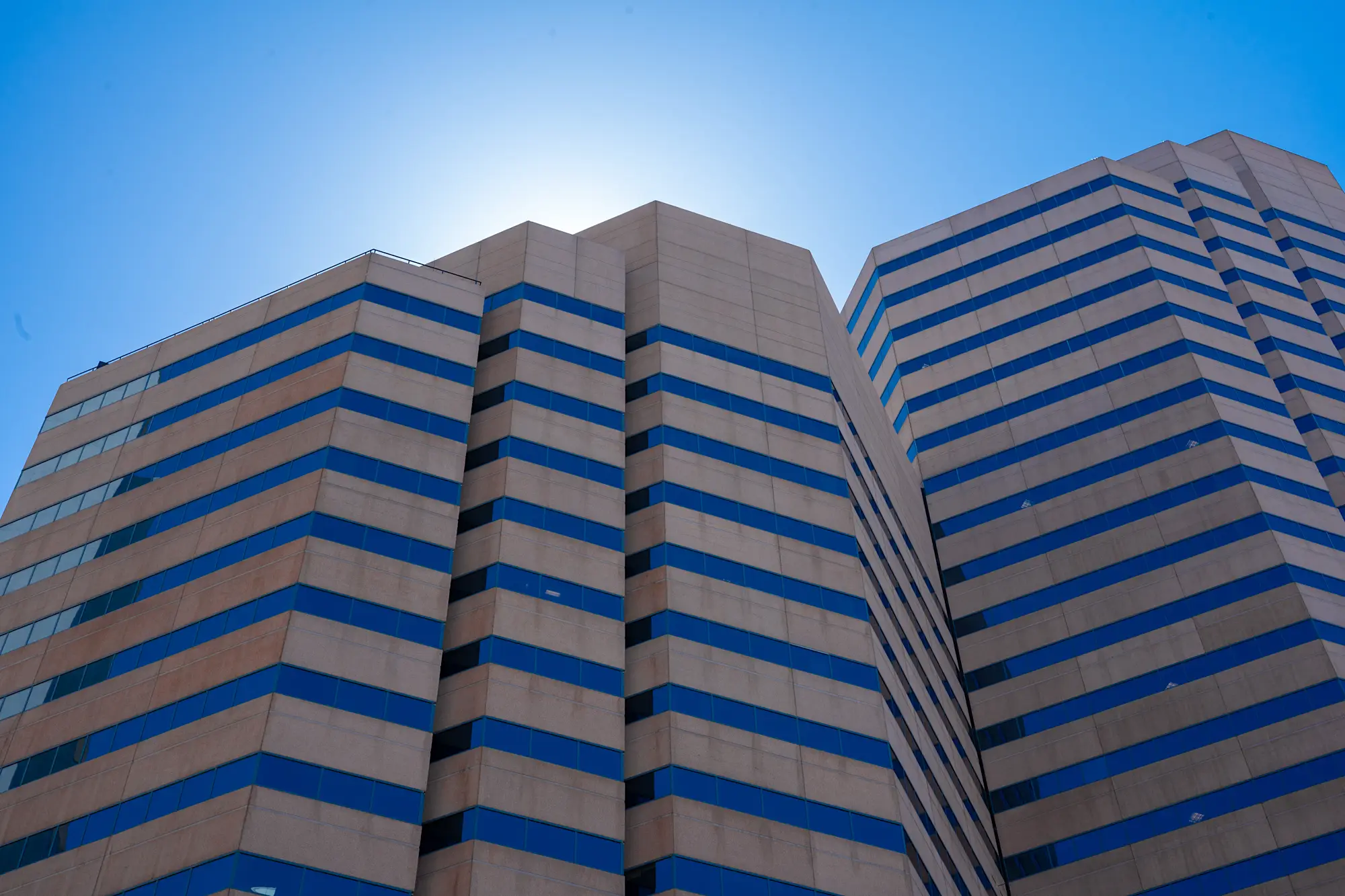 Denver skyline shot from below looking into the blue sky above