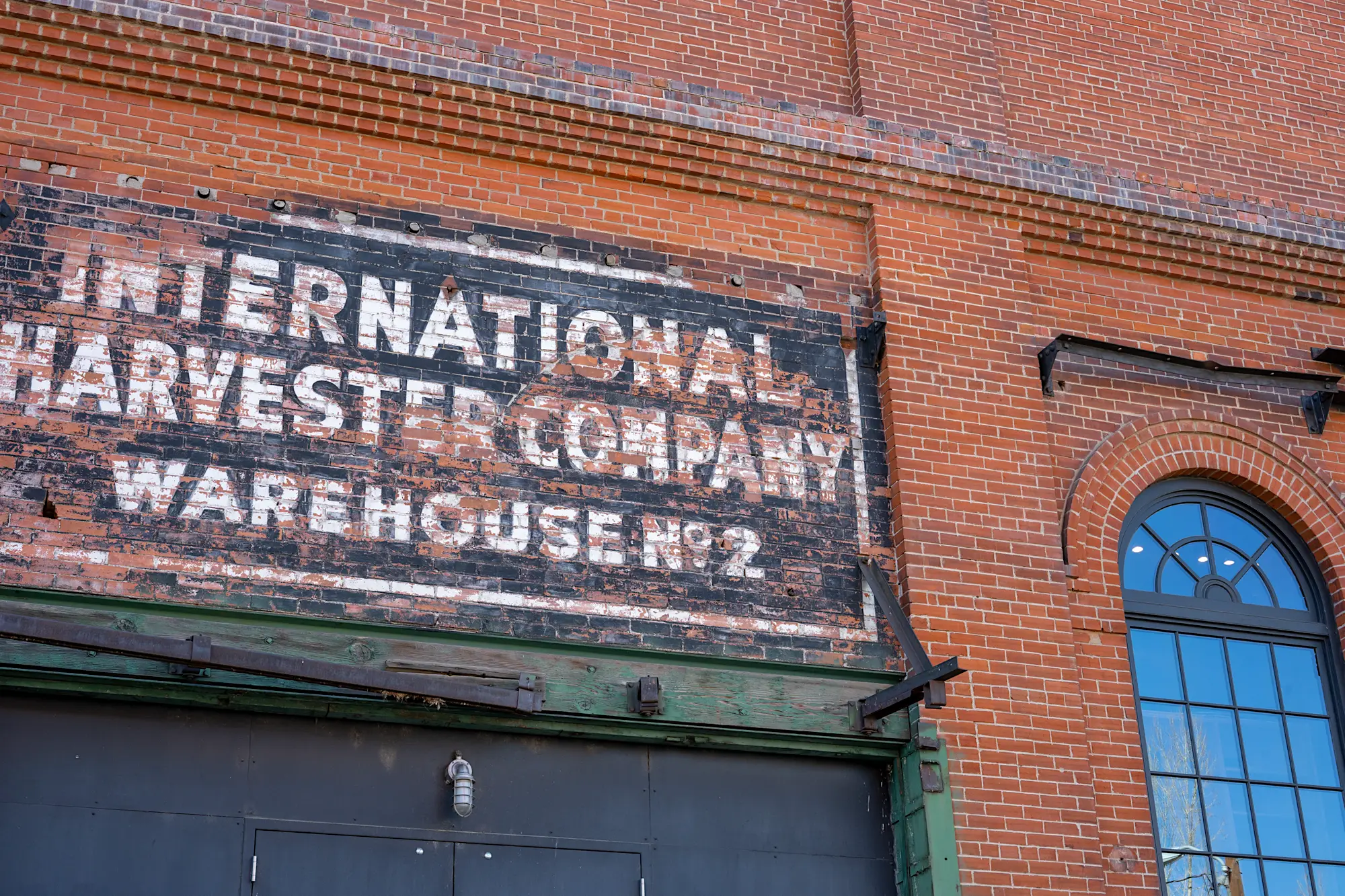 Worn out warehouse building sign against brick