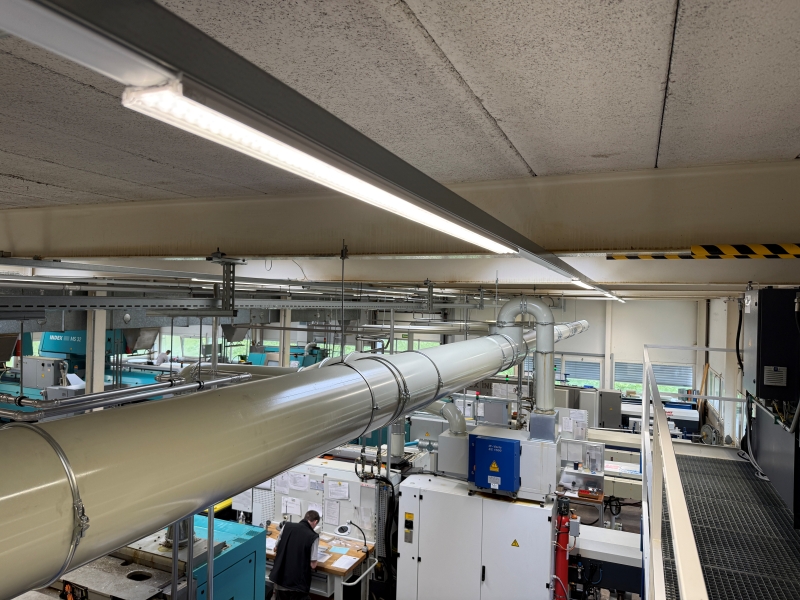 Moderne LED-Produktionsbeleuchtung in der Fertigungshalle der Schneto AG in Bennwil mit energieeffizienten LED-Leuchten und gleichmäßiger Ausleuchtung für präzise Arbeitsplätze.