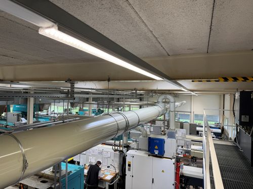 Moderne LED-Produktionsbeleuchtung in der Fertigungshalle der Schneto AG in Bennwil mit energieeffizienten LED-Leuchten und gleichmäßiger Ausleuchtung für präzise Arbeitsplätze.