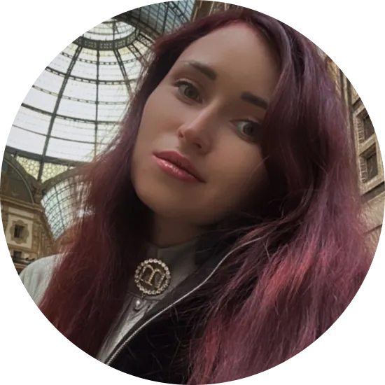 жінка з довгим рудим волоссям у чорній куртці