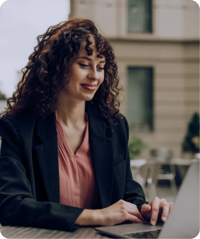 a woman sitting at a table using a laptop computer
