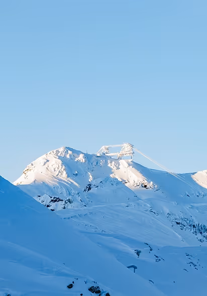 homme de dos face à la montagne enneigée Hôtel Marielle de Val Thorens