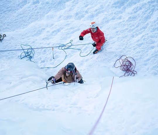 Guide et sa cliente qui monte une cascade glace