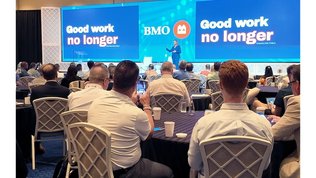 Audience member photographing Lisa Bragg on stage at BMO