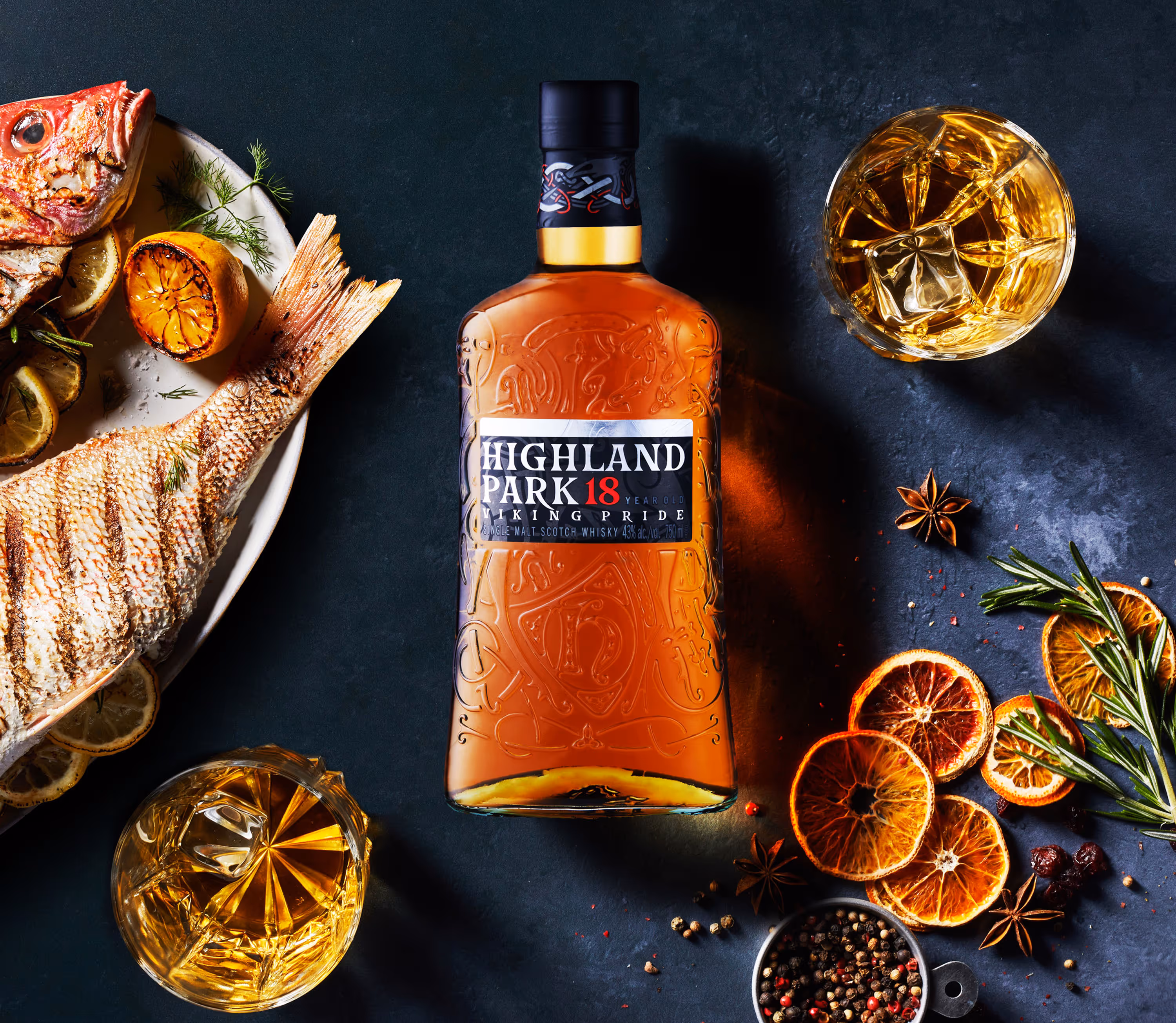 This brooding and intense photograph of Highland Park's 18 year scotch whiskey, surrounded by flavor pairings like rosemary dried oranges star anise and roasted red snapper. Photography by Christi Chambers.