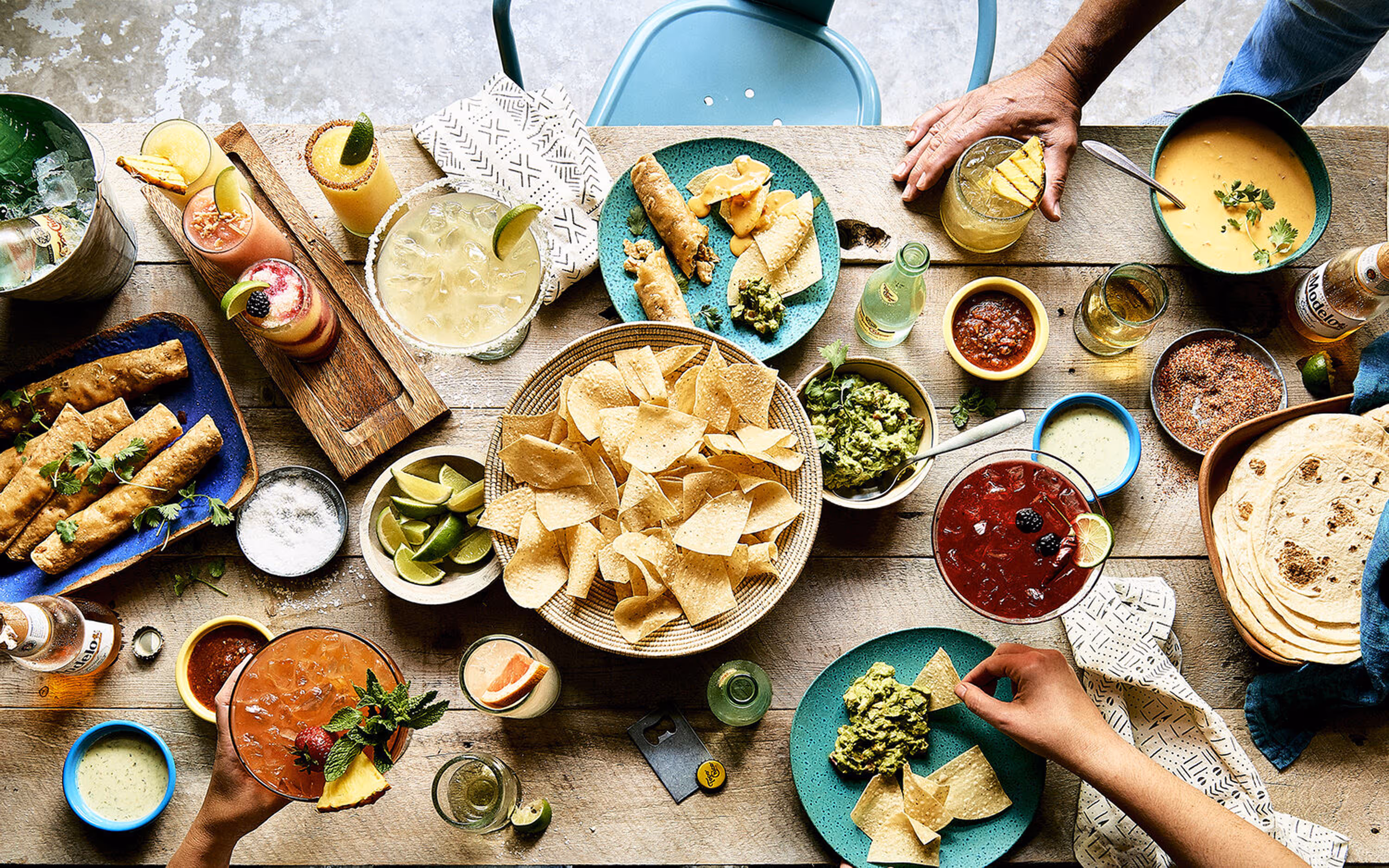 An overhead view of a table with a group of friends sitting down to a Mexican-American inspired feast. Photograph by Ralph Smith.