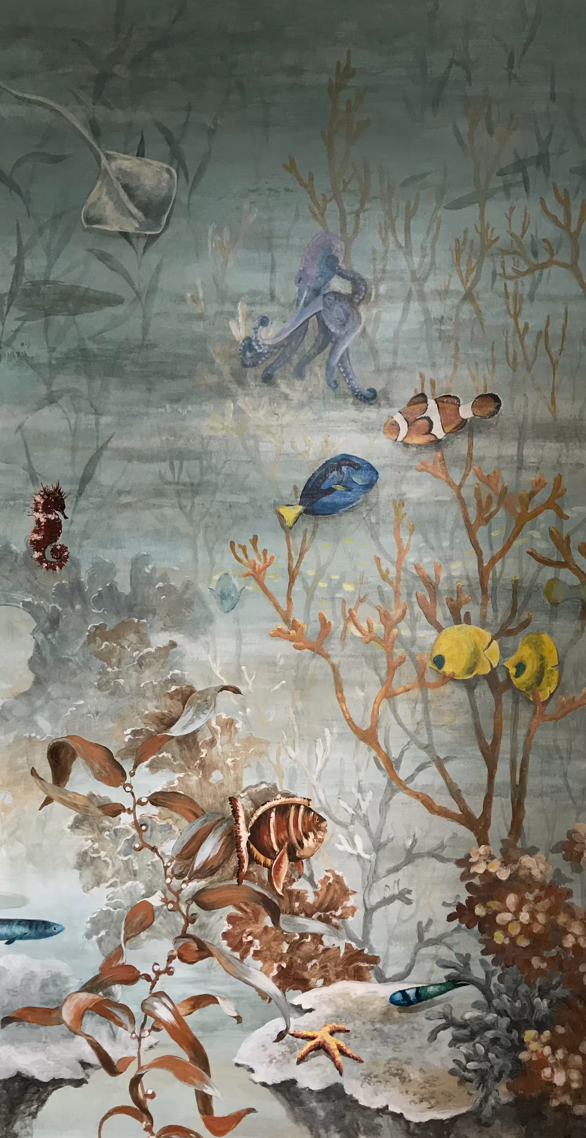Children’s bedroom mural by a London mural painter depicting a realistic underwater scene with colorful fish including clownfish, seahorses, squid, and more, inspired by vibrant ocean life.