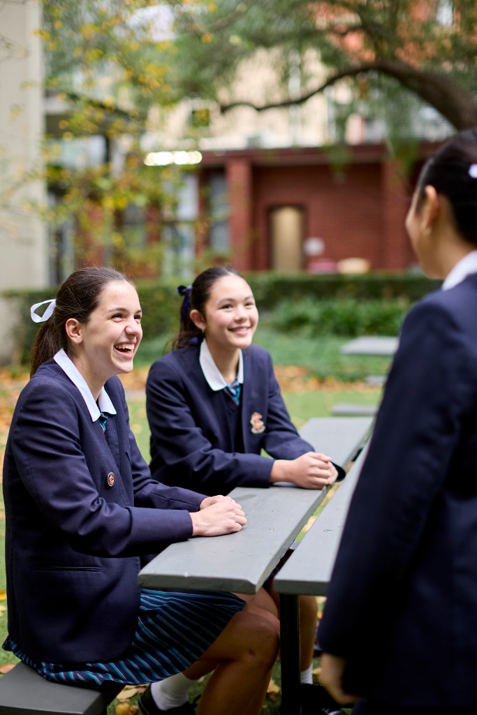 Sacré Cœur students laughing together at outdoor tables during Twilight Open Day