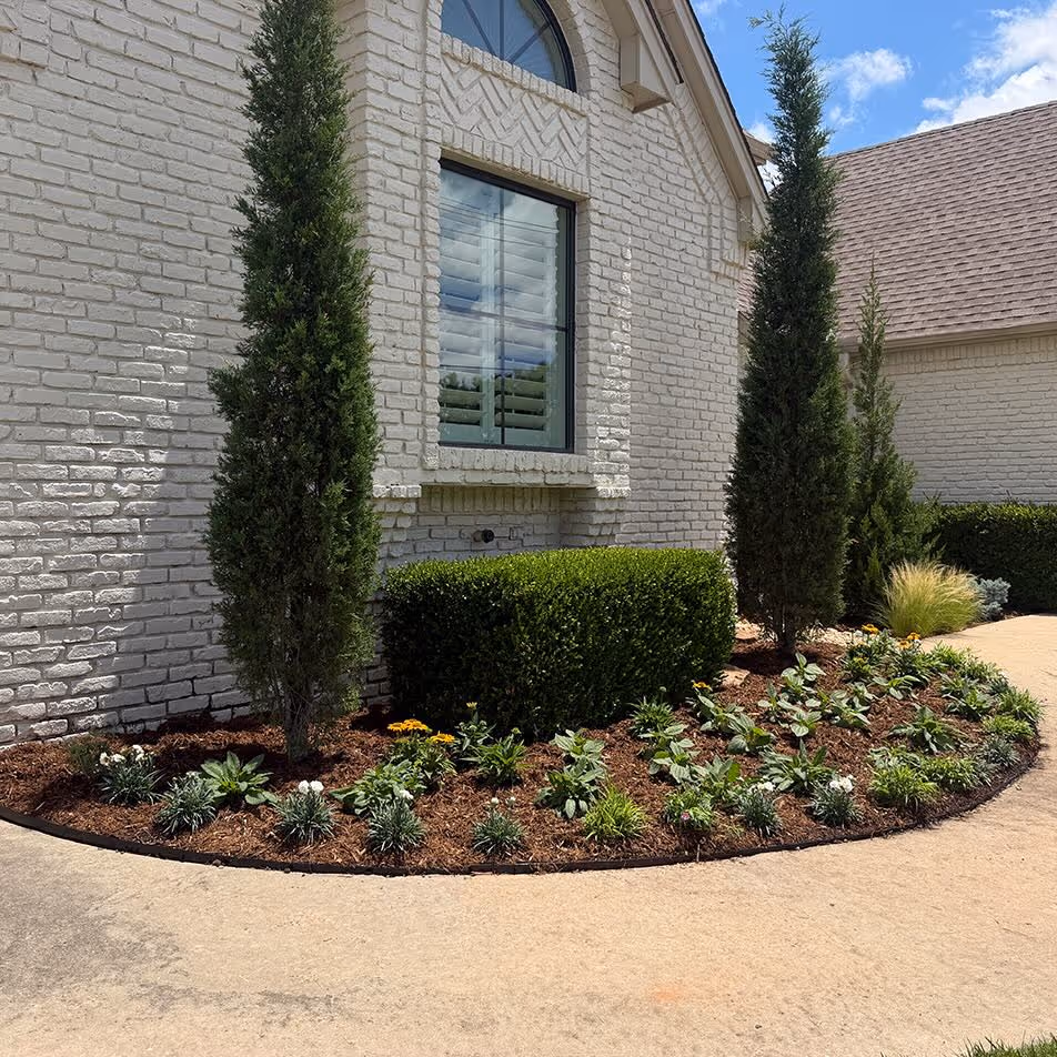 A front yard with a beautful garden and freshly cut lawn