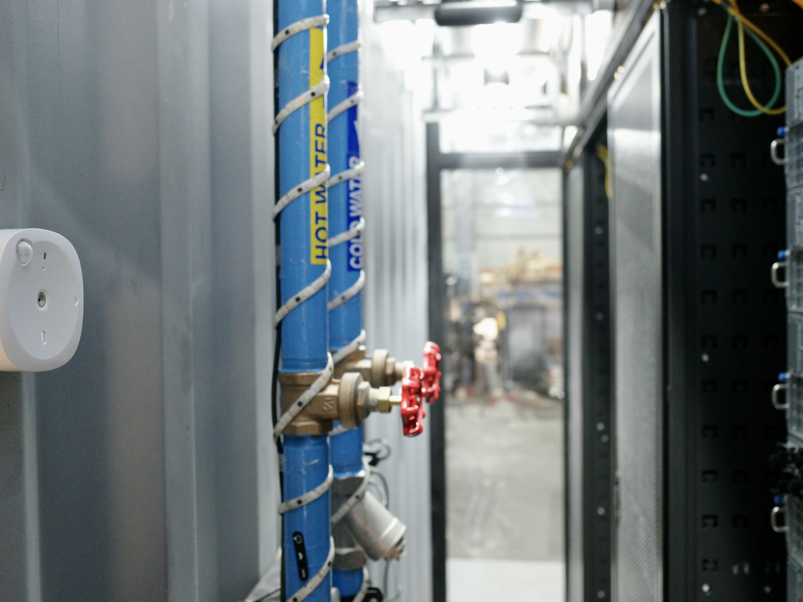 Butlr thermal sensor mounted beside chilled water pipes and a rack