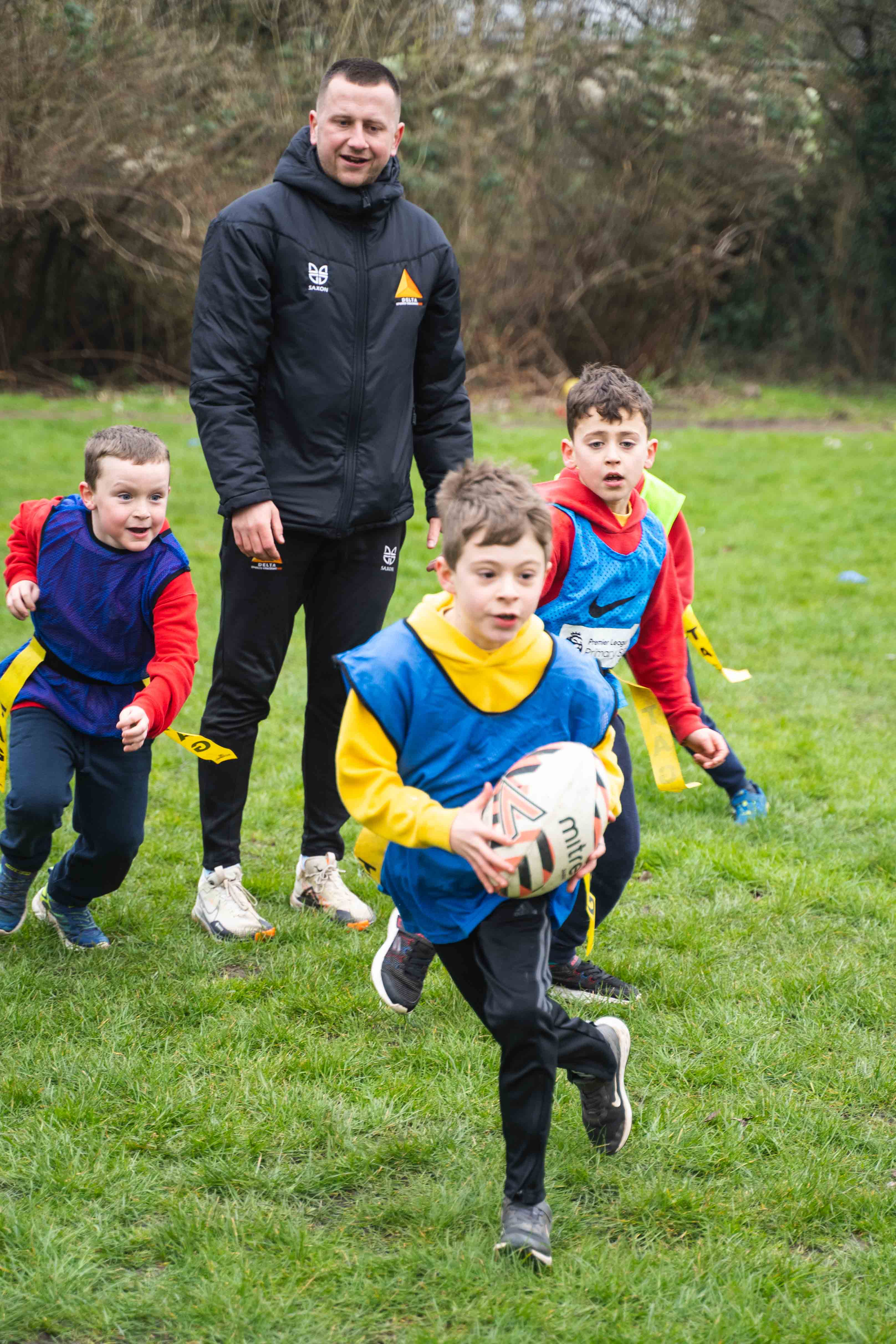 Children running in tag rugby sports camp
