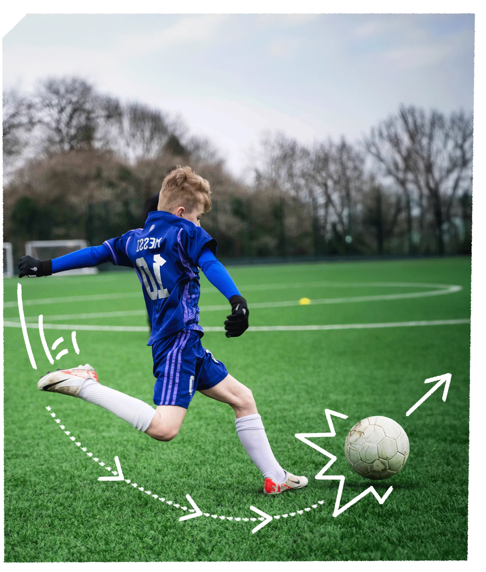 Young kid kicking football on a astro-turf football pitch