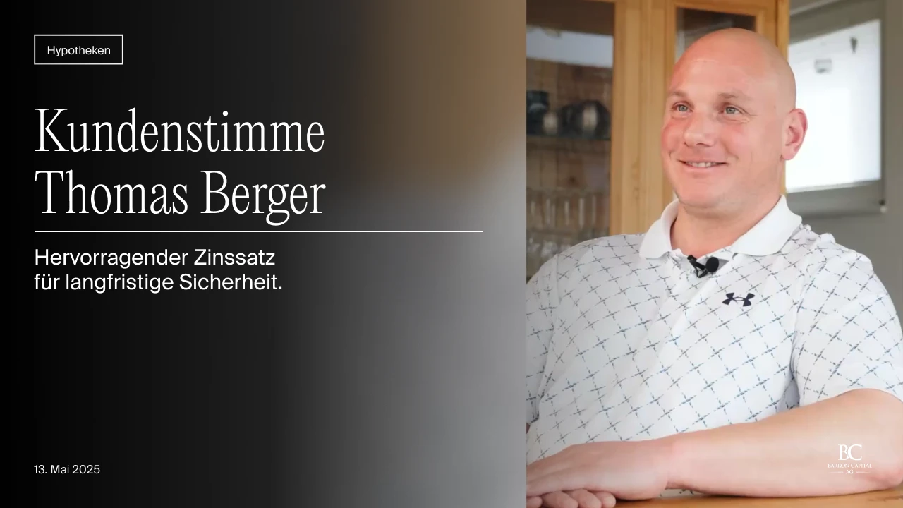 Porträt von Thomas Berger, sitzend, lächelnd in einem hellen Raum mit Holzregalen im Hintergrund.
