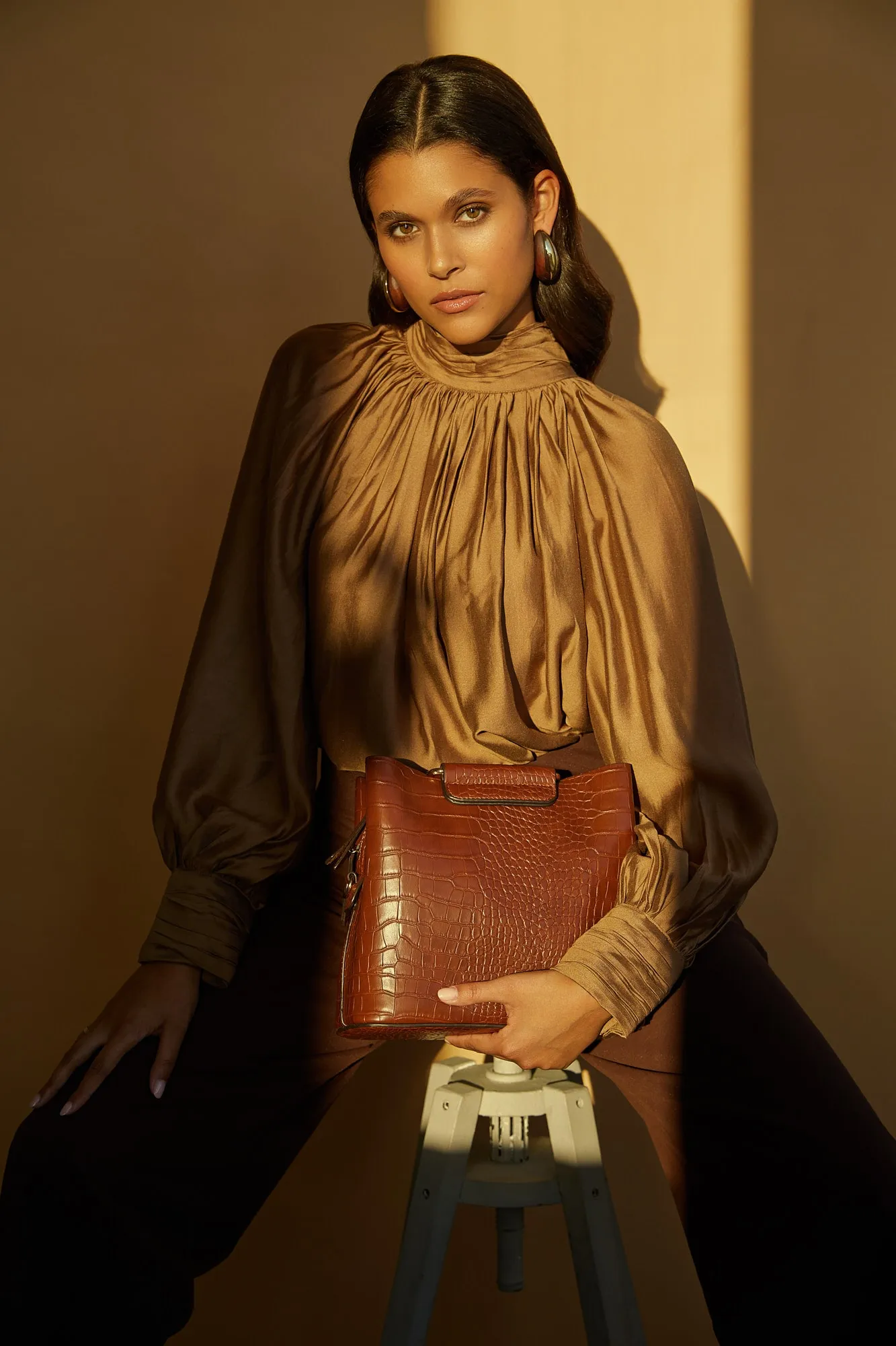 Eine Frau mit lockigem Haar trägt einen weißen Pullover.