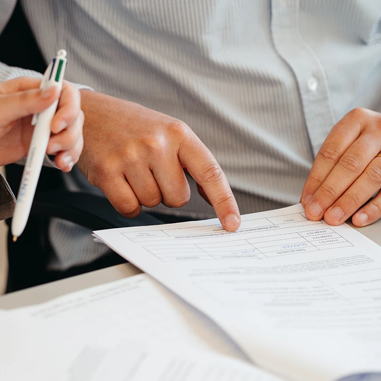 Mains tenant un document avec stylo Fenyx Conseil