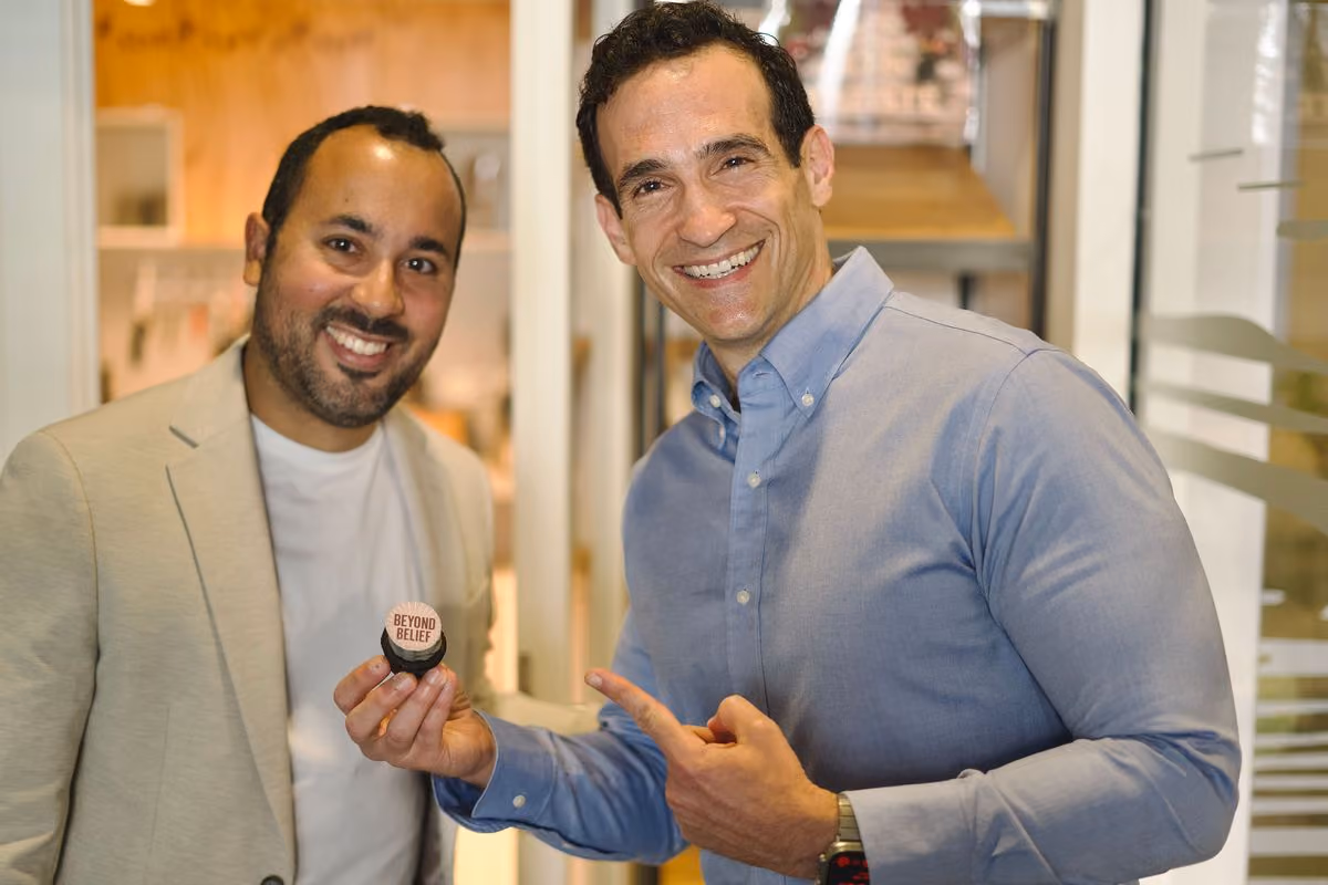 Nir Eyal and Ricardo Monagas holding a "Beyond Belief" cupcake at Nir Eyal's Beyond Belief keynote in Prague