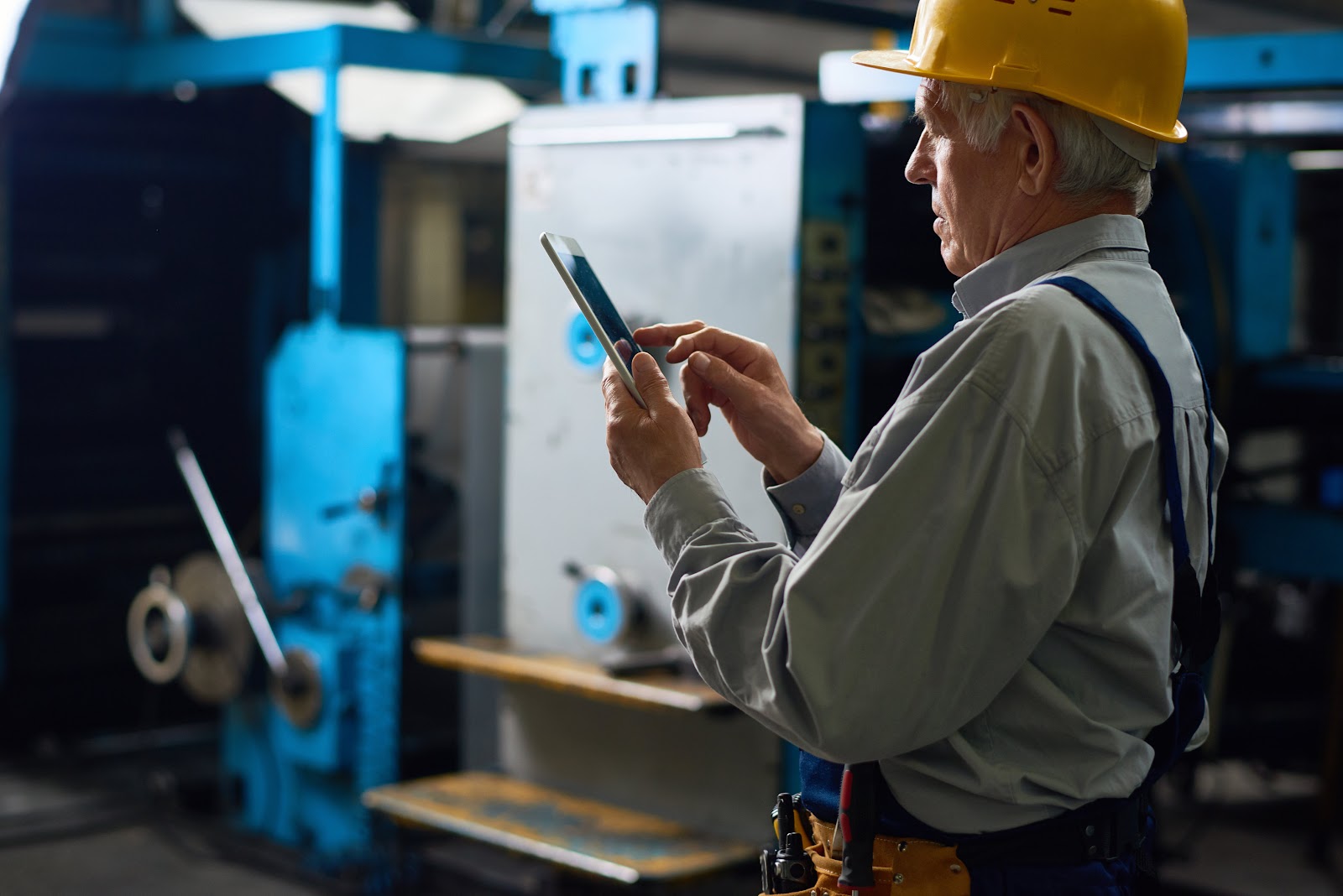 A maintenance technician using a tablet to read a digital SOP.