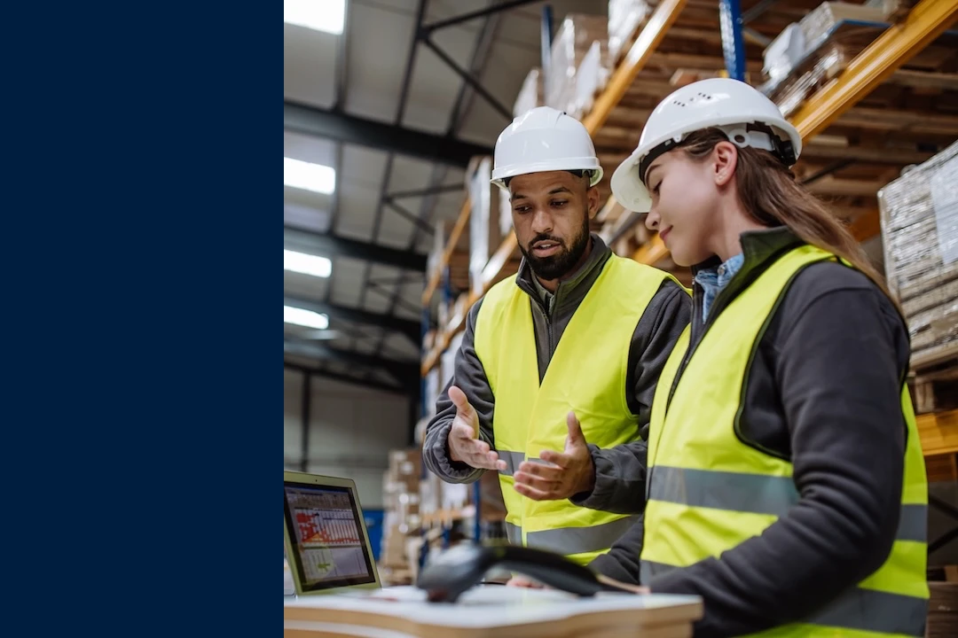 Warehouse manager talking with logistics employee in warehouse