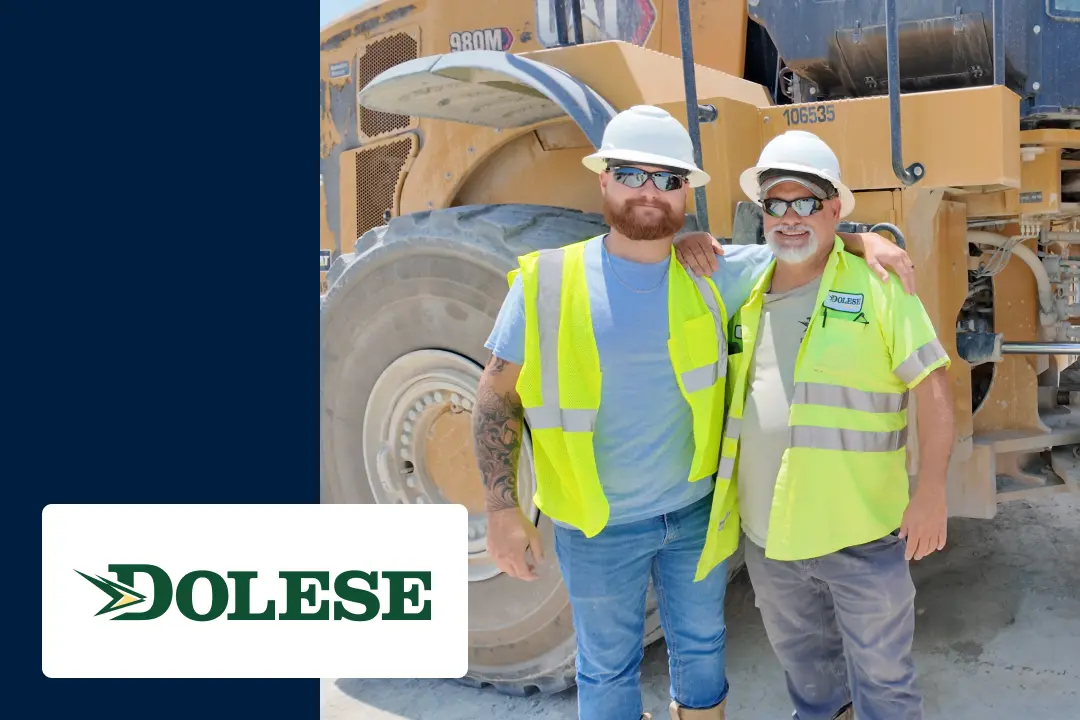 Dolese Bros industrial maintenance workers in safety vests and hard hats stand in front of a machine