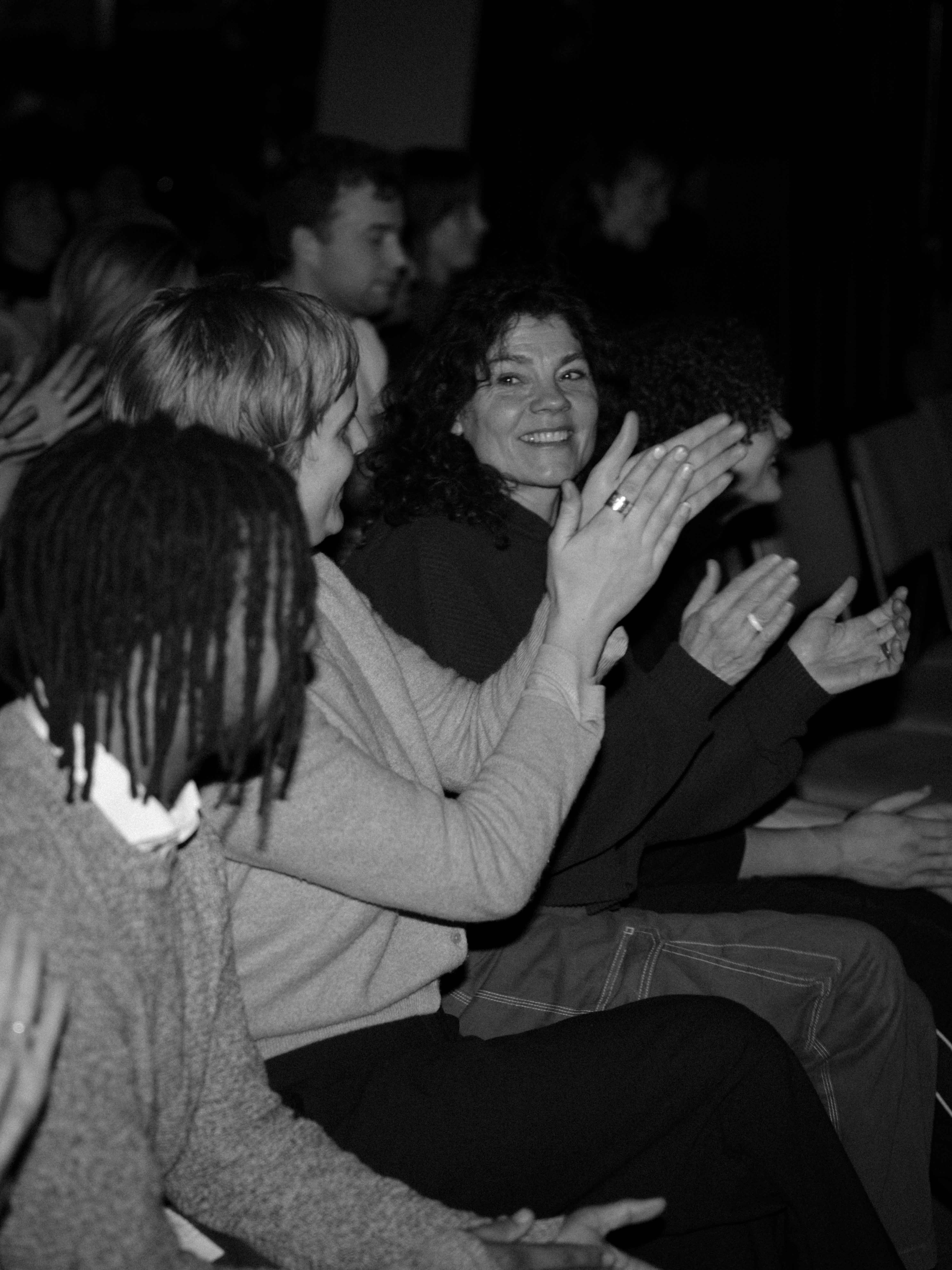 Een zwart wit foto van applaudiserende mensen.