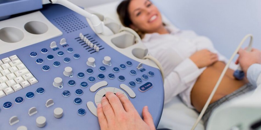 Sonographer performing an ultrasound exam on a pregnant patient