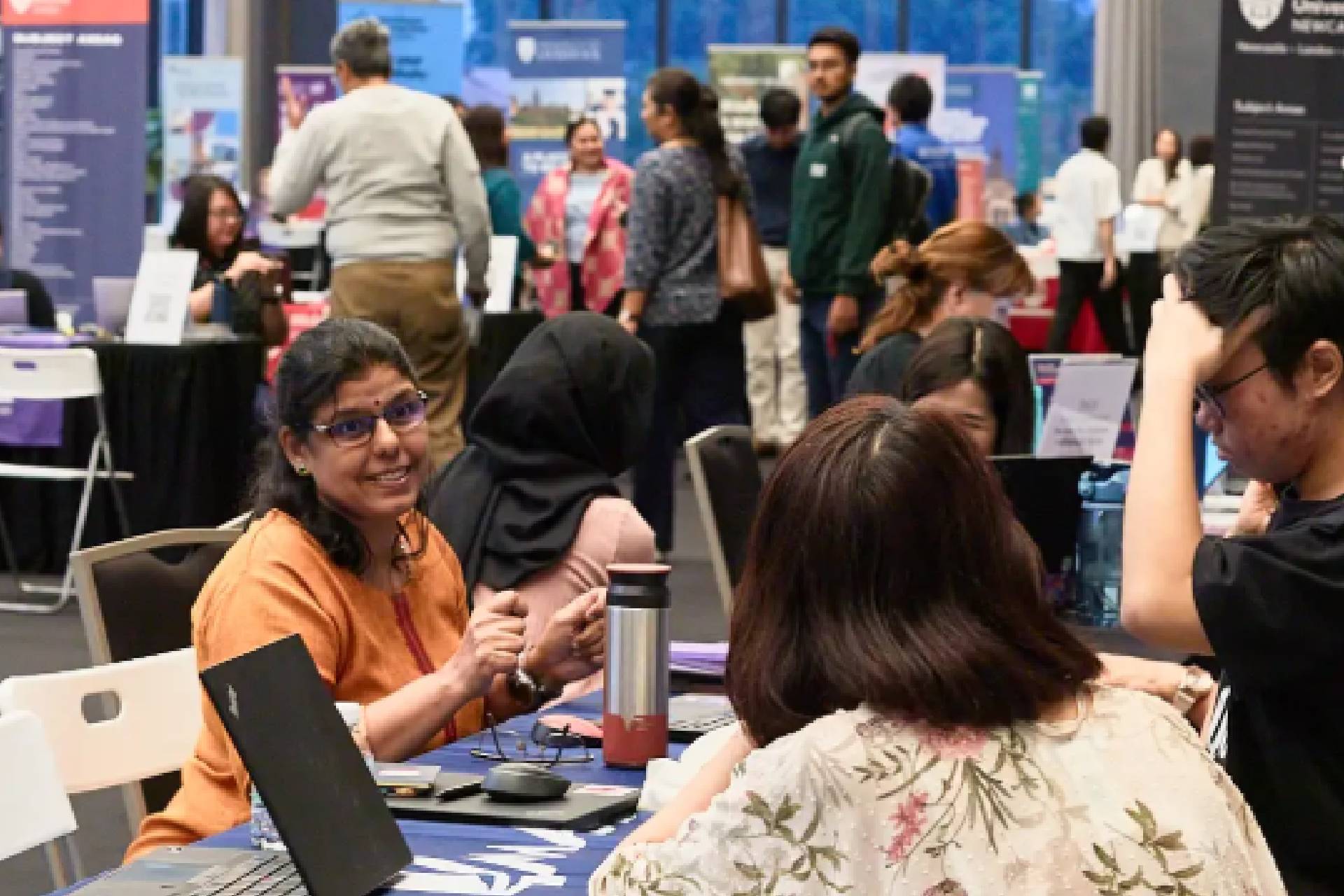 Students receiving overseas scholarship application guidance at an education fair