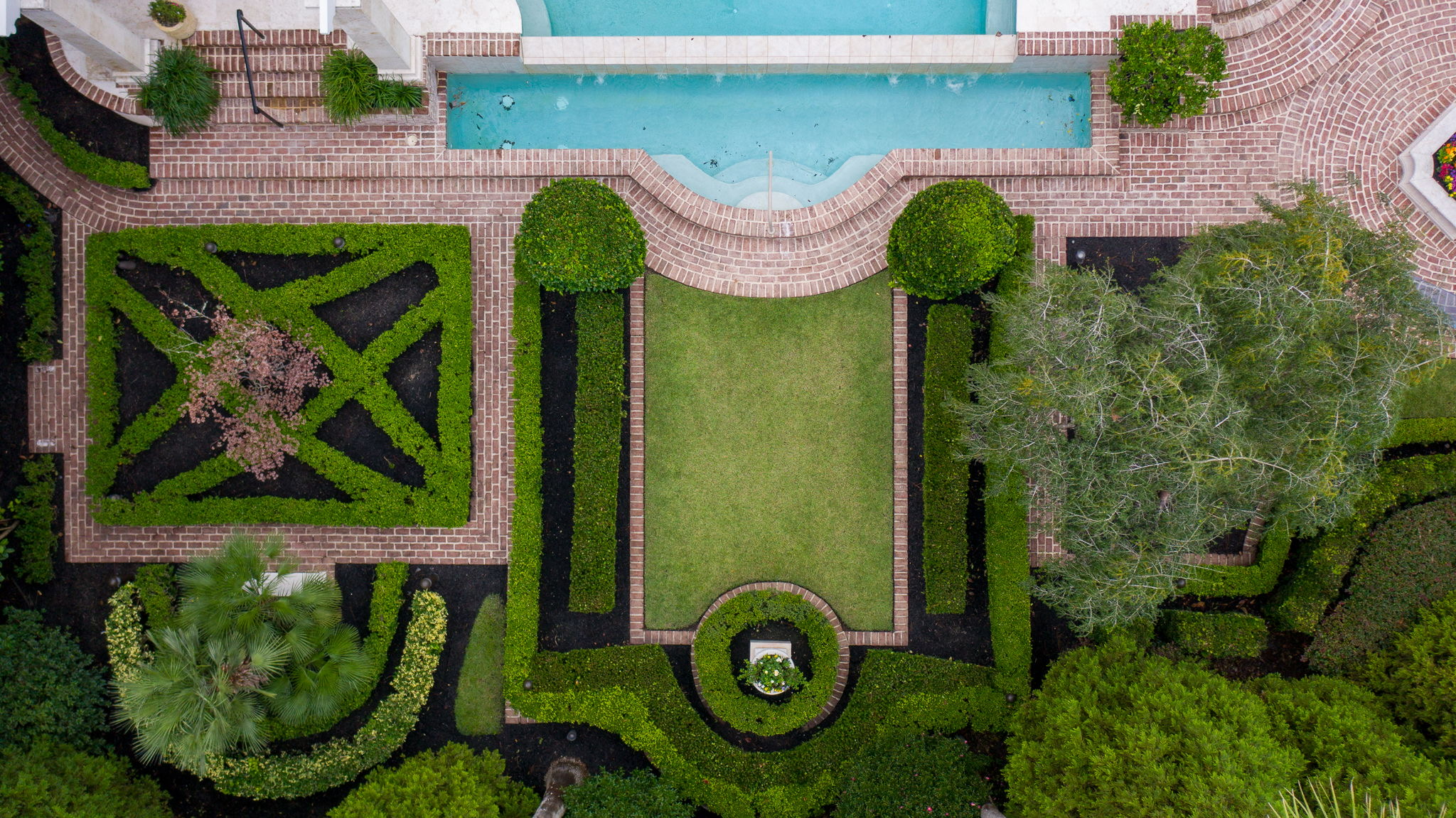 A design detail shot of wicker porch furniture with coastal throw pillows and a tray of sun-bleached seashells