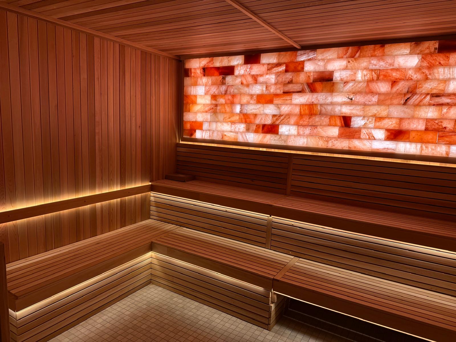 Custom Hot Stone Sauna features a Pink, Hand Cut Salt Wall and bespoke seating.