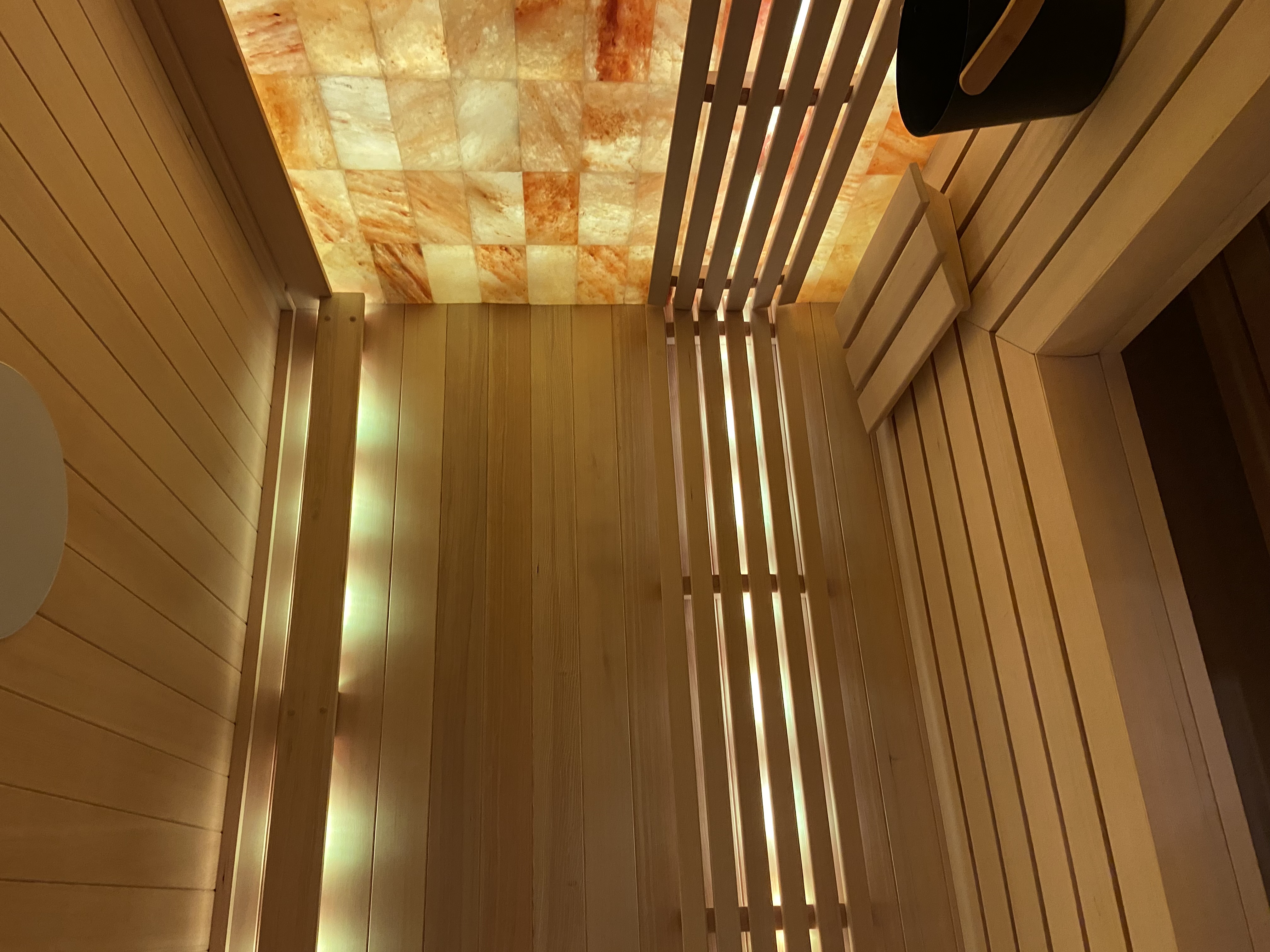 Backlit Himalayan salt brick wall inside a custom sauna by Heritage Saunas