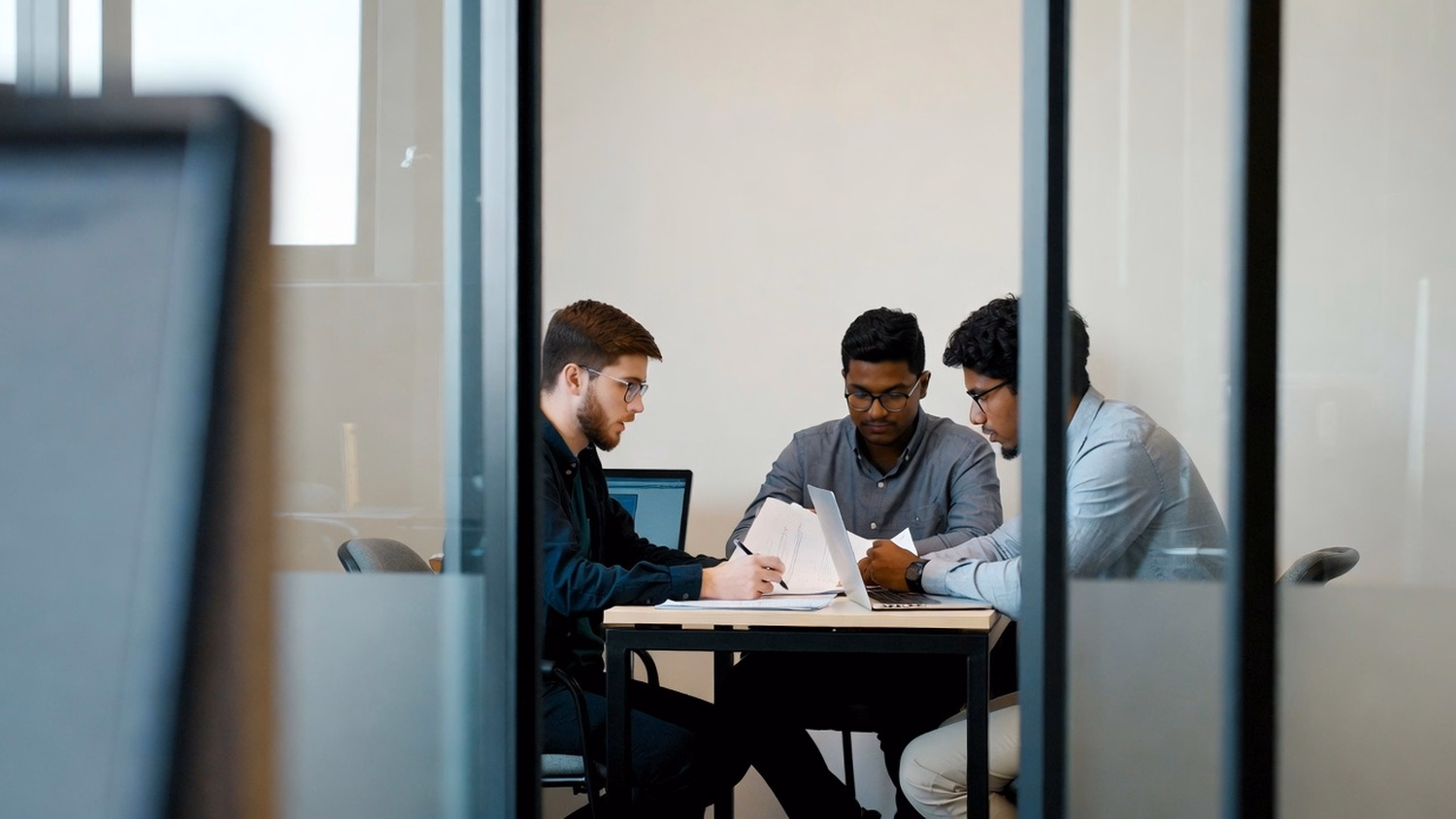 SMALL CONFERENCE ROOM An IT professional  three people seated around a small