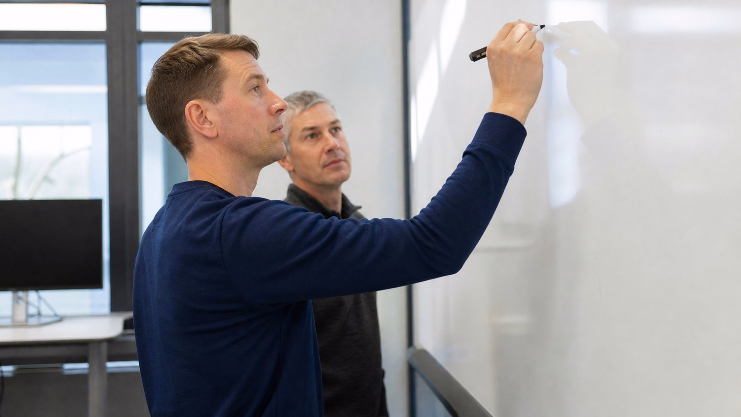 WHITEBOARD SESSION An IT professional one or two people standing at a whiteb