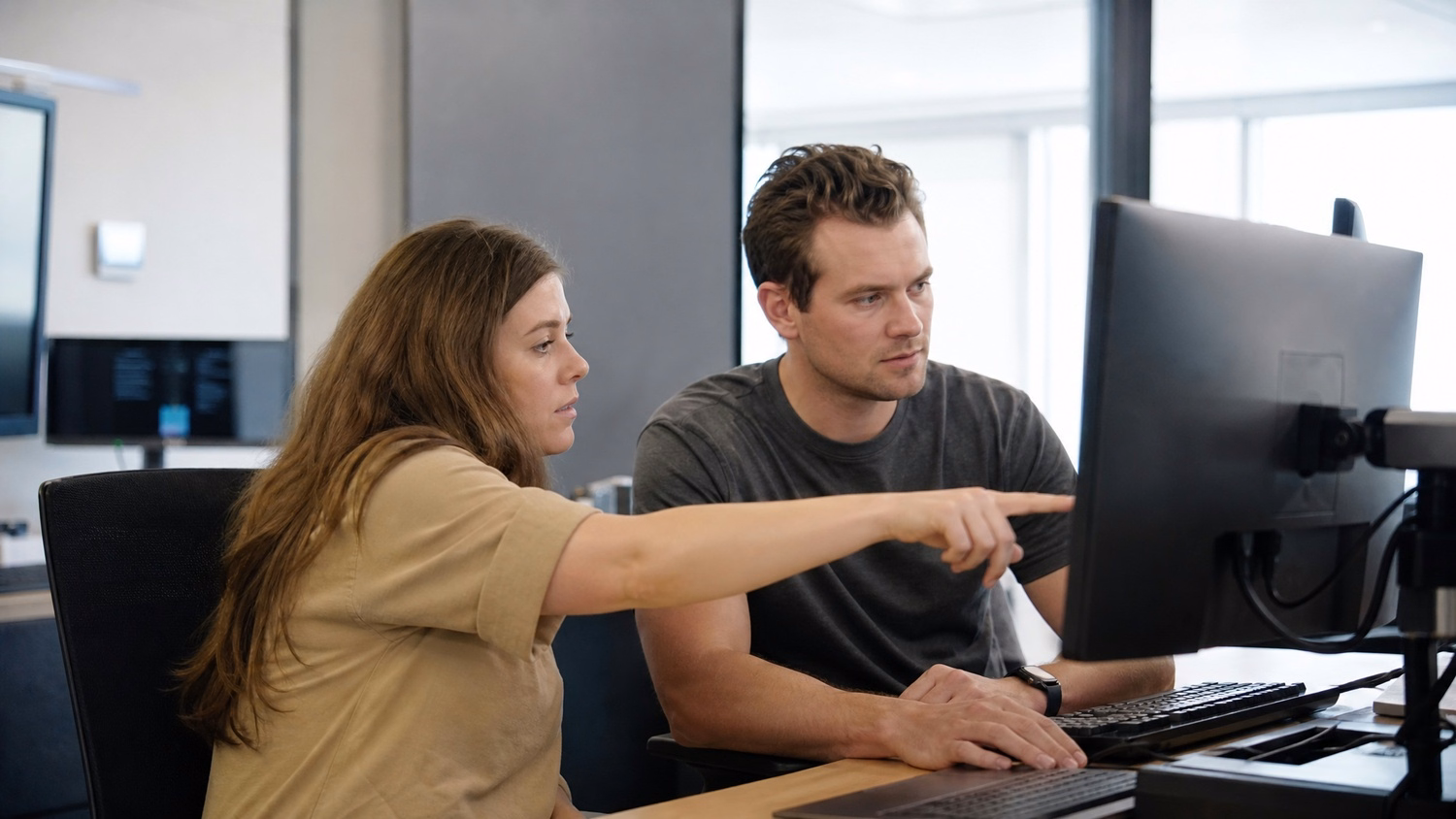 SIDE-BY-SIDE PAIR An IT professional two people seated side by side reviewin