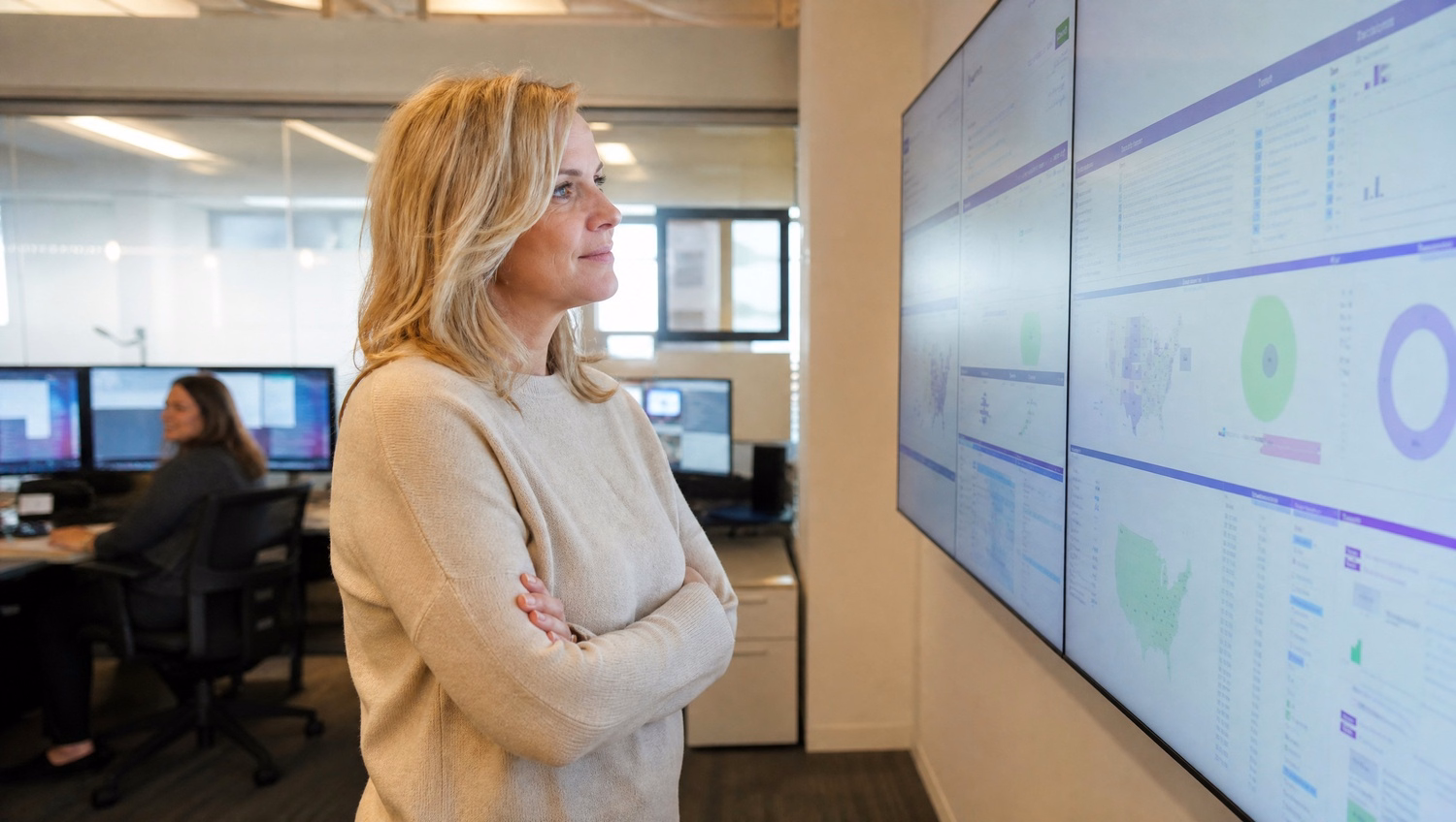 Woman reviews complex SharePoint migration dashboard on wall display