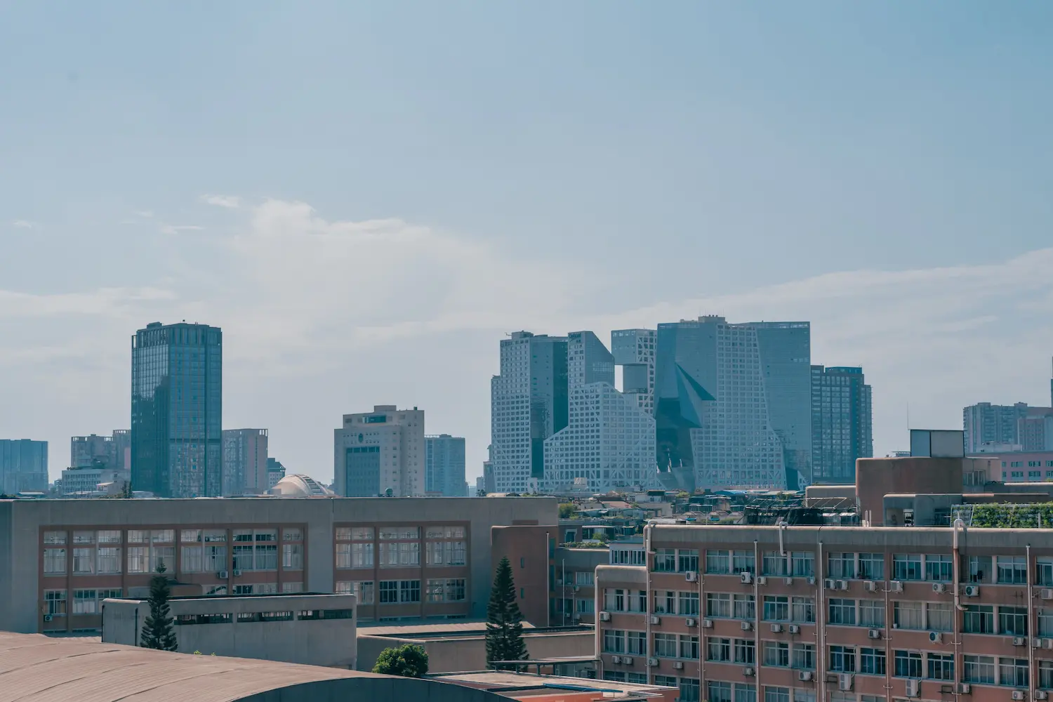 Vue panoramique d'un paysage urbain avec des gratte-ciel imposants et un ciel bleu clair.