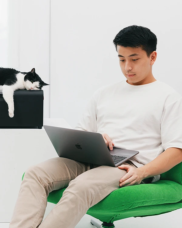 Portrait of Sam Mei working with a cat.