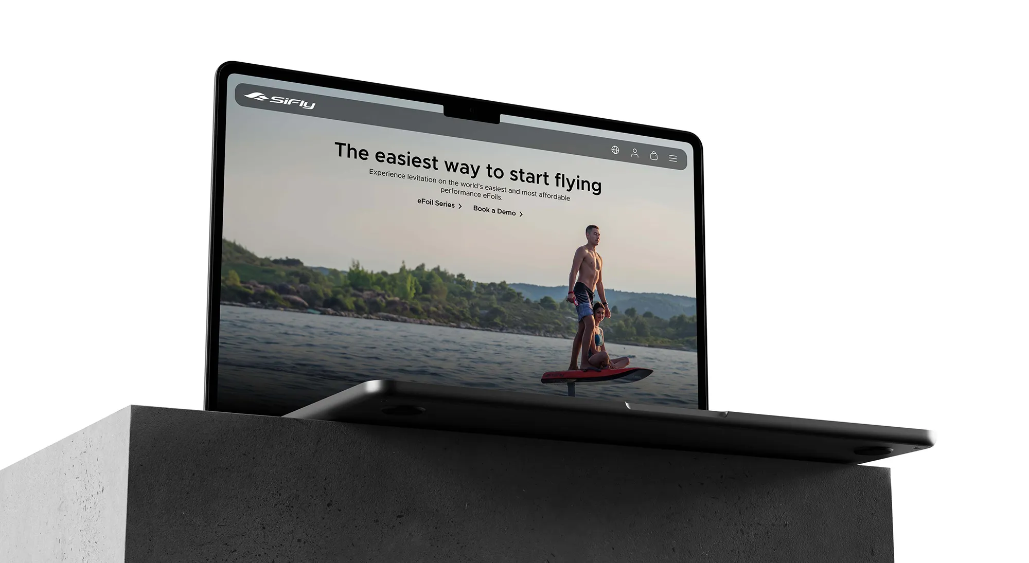 Laptop displaying a website featuring two people on a red eFoil in the water 