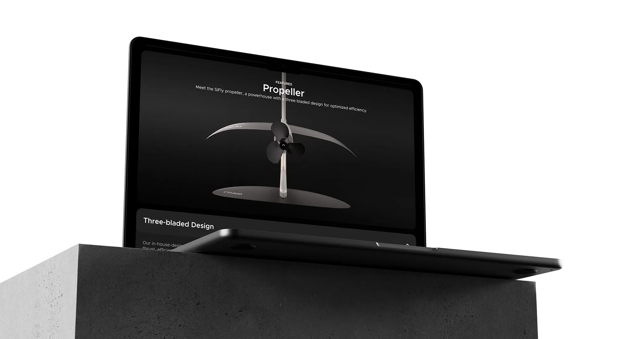 Black laptop on a concrete pedestal displaying a product page for a three-bladed propeller design.